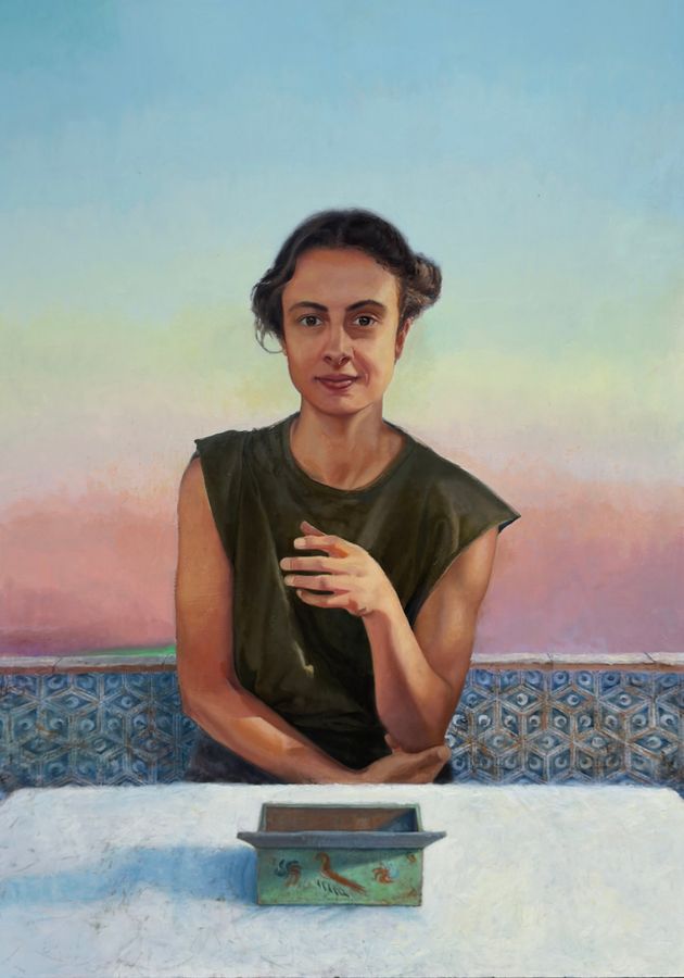 Retrato de una mujer sentada ante una mesa blanca con una caja verde, sobre un cielo degradado y un zócalo de azulejos